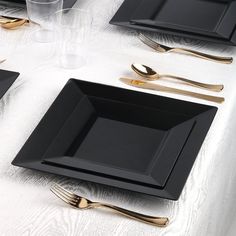 black and gold place settings on a white table cloth