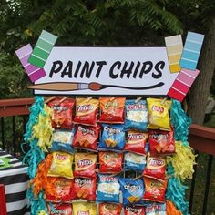 a sign that says paint chips on it with some candy bags in front of it