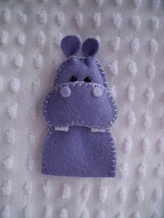 a purple stuffed animal on a white blanket