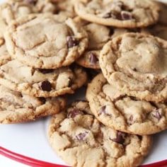 a plate full of chocolate chip cookies on top of a red and white tablecloth