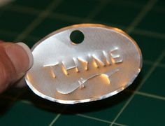 a hand holding a metal tag with the word time printed on it