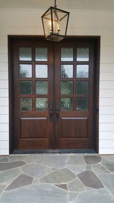 the front door to a house with two lights on it