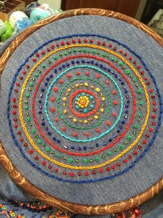 a close up of a circular object made out of fabric and wood with beads on it