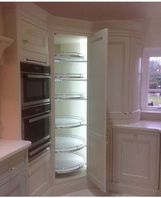 an empty kitchen with two ovens in the corner, and no one is inside