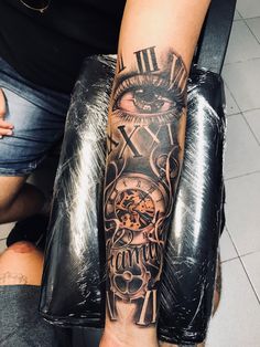 a man's arm with a clock and skull tattoo on it, next to another person