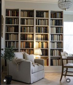 a living room filled with furniture and lots of bookshelves full of books next to a dining table