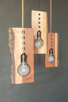 three light bulbs are hanging from wooden beams