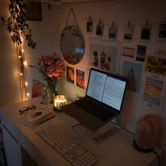 a laptop computer sitting on top of a white desk next to a keyboard and mouse