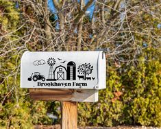 a mailbox with the words brook haven farm on it in front of some trees