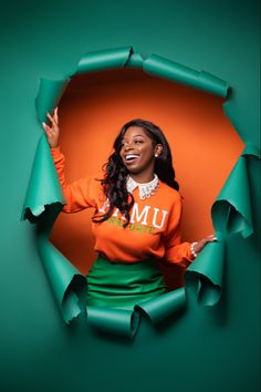 a woman in an orange shirt and green skirt with torn up pieces of paper around her