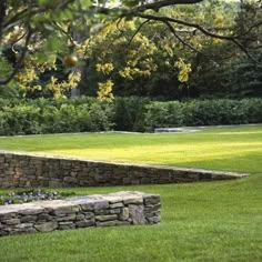 a stone bench sitting in the middle of a lush green field