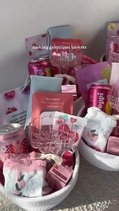 two white baskets filled with pink items on top of a table next to each other