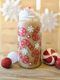 a glass jar filled with whipped cream and candy canes on top of a wooden table