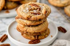 a stack of pecan cookies sitting on top of a white plate