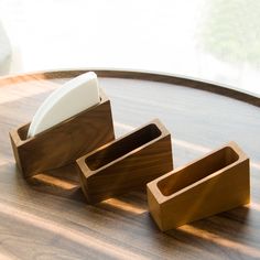 three wooden containers sitting on top of a table next to an object in the middle