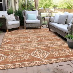 an outdoor area with couches, chairs and rugs