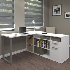 a computer desk with a laptop on top of it next to a bookshelf