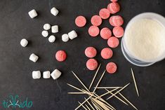 marshmallows, sugar cubes and toothpicks on a black surface