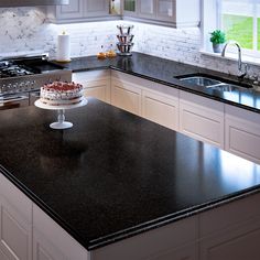 a cake sitting on top of a counter next to a stove and sink in a kitchen