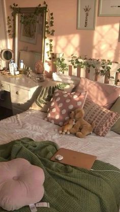 there is a teddy bear on the bed with pillows and blankets in front of it