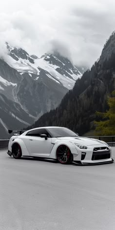 a white sports car parked in front of mountains