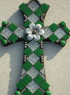 a green and white cross with flowers on it's sides is seen from above