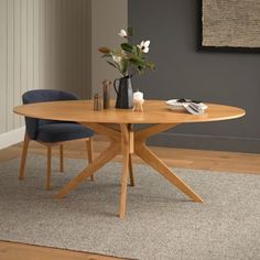 a wooden table sitting on top of a carpeted floor next to a blue chair