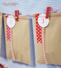 some brown paper bags with red and white tags hanging from it's sides on a wall