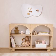 a wooden shelf with books and stuffed animals on it in a child's room