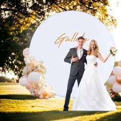 a bride and groom standing in front of a giant balloon sign with the word golly written on it