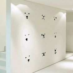 there are many panda faces on the wall in this room, and one is black