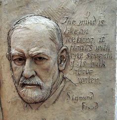 a carving of an old man's face on a stone wall with words written in cursive writing