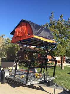 a trailer with an orange tarp on the top and some tools attached to it