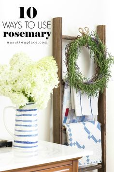 a vase filled with white flowers sitting on top of a table next to a towel rack