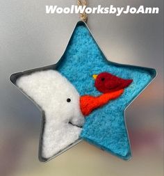 a felt star ornament with a bird and a cardinal on it's side