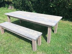 a wooden table and bench sitting in the grass