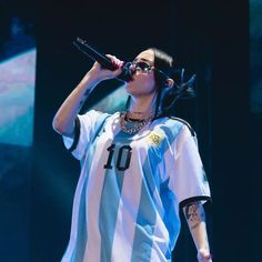 a woman with black hair and sunglasses on stage