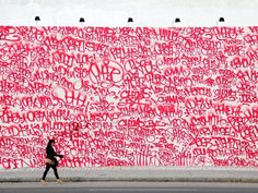 a person walking past a wall covered in graffiti