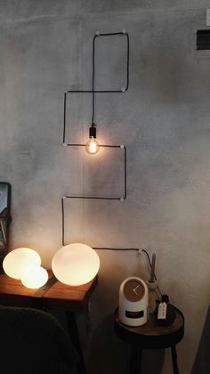 a lamp that is sitting on top of a wooden table next to a wall mounted speaker