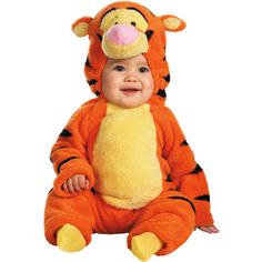 a baby dressed in a tiger costume sitting on the ground with a heart shaped nose