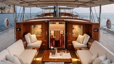 the inside of a boat with couches and tables on it's deck in the water