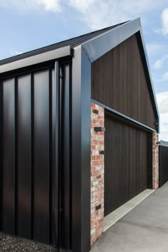 a black garage with brick and steel siding