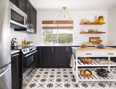 a kitchen with black cabinets and white tile flooring