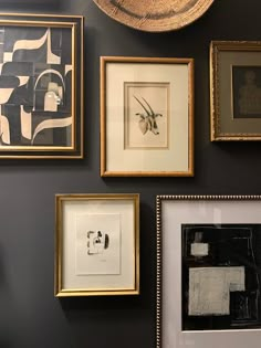 many framed pictures are hanging on the wall next to each other, including one with a hat