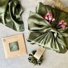 the green satin bow is next to its packaging