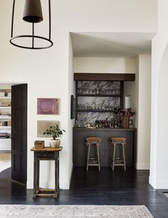 a living room with two stools and a bar