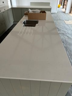 an empty kitchen counter with two sinks in the center and one on the other side