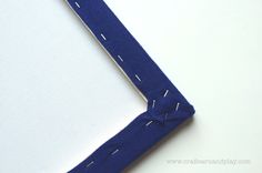 a piece of blue fabric with white stitching on it and the edge of an object that has been cut in half