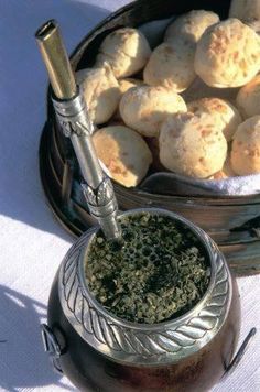 a bowl full of food next to a metal container filled with powdered sugar and herbs