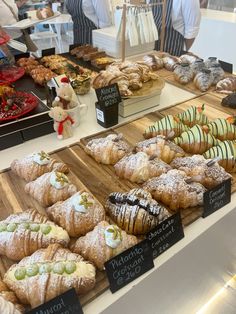 many different types of pastries on display at a bakery